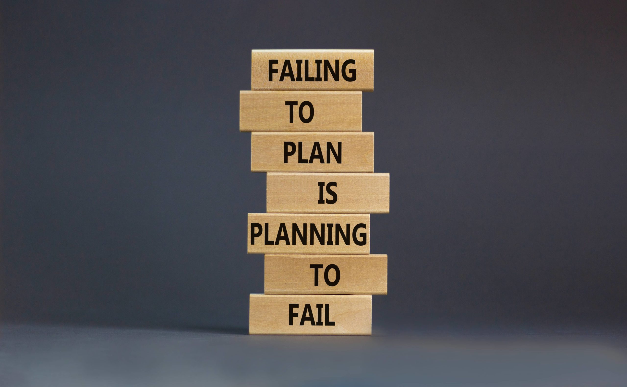 Image of jenga blocks with the words failing to plan is planning to fail written on them in black