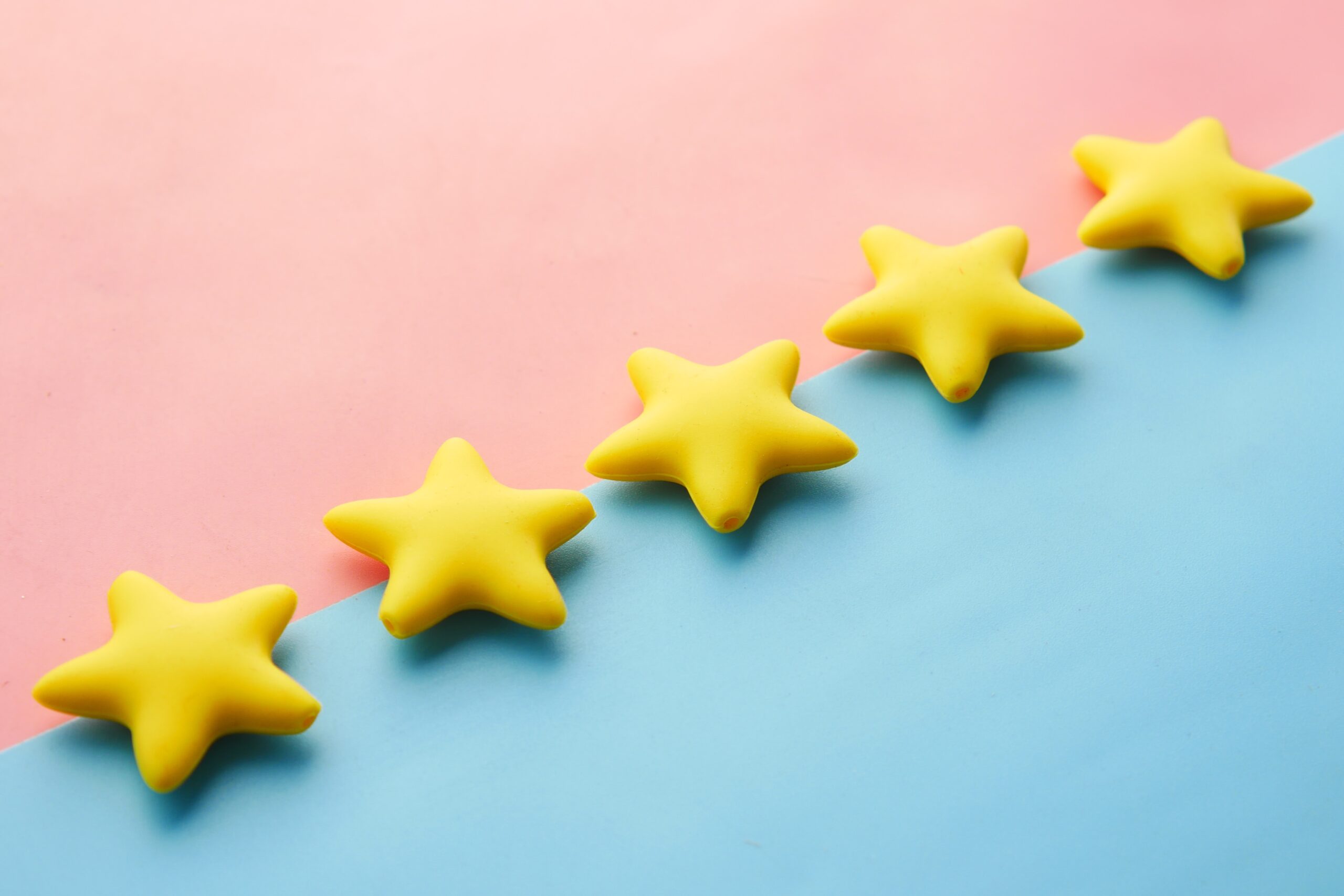 5 candy yellow gold stars against a pink and blue background